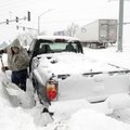Rick Wheeler of Rogers digs his truck out of the snow Wednesday in a parking lot near Thompson Stree...