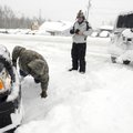 Rick Wheeler, right, looks for a place to hook a tow rope to his truck after Jeff Rowden offered to ...