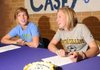 Fayetteville seniors Casey O’Brien, left, and Anne Mitchell laugh Tuesday before signing with John Brown University in Siloam Springs and Centre College in Danville, Ky., respectively.