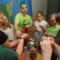 GOING GREEN Jason Quail of Bentonville hands out special gifts Friday to members of the Root Element...