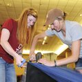 PROM PREPARATIONS Micah Sizemore, left, helps Jessica Anderson staple tulle to decorate for the Spri...