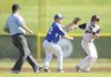 Rogers High’s Jake Rylee tags out Springdale High’s Bryce Neal after Neal was caught between second and third base Tuesday in Springdale.