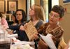 Lilian Bern, right, holds the matzah during a seder on Sunday. The Matzah is a top of unleavened bread.
