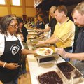 Longtime volunteer Lois Bryant, left, collects food on a plate Saturday from Mark Lindsay, Washingto...