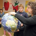 EARTH DAY ACTIVITIES Katie Teague holds the world in her hands as she teaches about the importance o...
