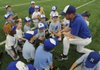 Darek Bunch, right, talks with young players in the Mountaineer Baseball Academy on April 17 at the Rogers High School turf room. The players learn fundamentals that will help them be better players.