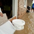 Business owners work to prevent rising waters from entering their business along College Ave. on Mon...