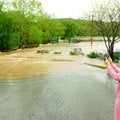 Alechia Buttry gets a picture of water flowing over the top of Lake Bella Vista dam in Bentonville o...