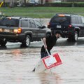 A man removes debris from a flooded College Avenue in Fayetteville on Monday, April 25, 2011.