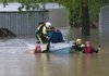 A water rescue team works Monday to evacuate residents from the Oak Glen manufactured housing park in Johnson after Clear Creek over ran its banks and flooded the complex.