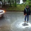 Lewis Price of Fayetteville stops to open a manhole cover to let water drain on West Trenton Bouleva...