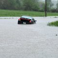 A car got stuck in a ditch after high waters pushed the vehicle off the road when the driver attempt...