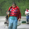Residents walk away from a housing area in Johnson after being rescued by Johnson Fire Department me...