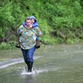 Residents walk away from a housing area in Johnson after being rescued by Johnson Fire Department me...