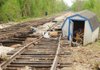 A firefighter with the Fayetteville Fire Department surveys flood damage Tuesday along a section of Arkansas & Missouri Railroad track behind the Blossom Hill facility in Johnson.