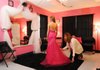 Shay Hopper, assistant director of the Glass Slipper Prom Project, helps Caitlin Lamb straighten the dress she models at the project’s new home on Fayetteville High School’s west campus.