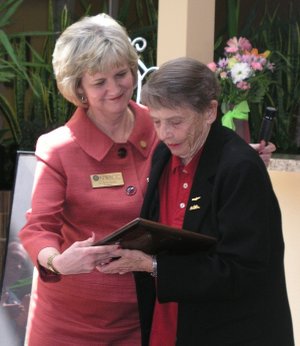 Becky Paneitz, left, and Virginia Mocivnik look over a plaque presented to Mocivnik during a grand opening ceremony for Ginnie’s Place.
