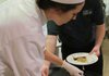 Culinary student Sara Williams positions a scoop of Black Pepper Milk Chocolate ice cream in a pistachio cup prior to the serving of dessert at NorthWest Arkansas Community College’s Chocolate Moonlight Cabaret on April 27.
