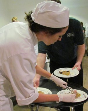 Culinary student Sara Williams positions a scoop of Black Pepper Milk Chocolate ice cream in a pistachio cup prior to the serving of dessert at NorthWest Arkansas Community College’s Chocolate Moonlight Cabaret on April 27.
