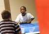 Taeshaun Clark, 7, watches as he makes a goal in a game of air hockey against Tyrique Scott, 7, at the Boys & Girls Club in Fayetteville on Monday. Proceeds from Altrusa’s Battle of the Badges will benefit a summer feeding program at the club.