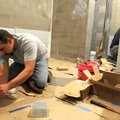 Jared Hamilton with We Set Tile tiles a wall in a bathroom Tuesday at the Sonora Elementary School i...
