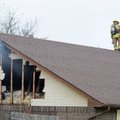 Members of the Springdale Fire Department get ready to open up a roof vent while battling hot spots ...