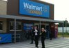 People walk in front of a yet-to-open Wal-Mart Express store in Gentry, Ark., Thursday, June 2, 2011. (AP Photo/Chuck Bartels)