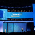 Mike Duke, President and CEO of Wal-Mart, center, speaks to shareholders as his image appears on scr...