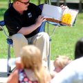 LITERACY FAIR Rogers’ Mayor Greg Hines reads on Saturday to a group of children and parents during t...