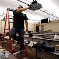 Justin Alvarado with Ford Audio and Video sets up a projector Wednesday in a classroom for the Colle...