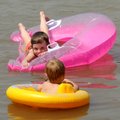 Ashley Robinson, 5, left, and Aidan Robinson, 3, float in cool water in the swimming area at Prairie...