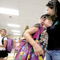 Principal Regina Stewman of Robert E. Lee Elementary School in Springdale, hugs second-grader Esmera...