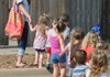 Caitlyn Beattie at Butterflies and Frogs Day Care in Springdale escorts children to the playground on Monday. The day care is one of the organizations that uses the Northwest Arkansas Child Care Resource and Referral Center for training.