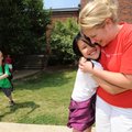 Kim Nguyen, a third-grader at Leverett Elementary School, gets a hug from principal Cheryl Putnam at...