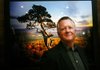 Photographer Ed Cooley poses for a portrait during the unveiling of his galler, the White River Gallery, Friday, June 10, 2011 in downtown Rogers.