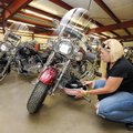 Heather Mathias of Tulsa, Okla., attaches her helmet to her 2005 Harley-Davidson Fatboy on Saturday ...
