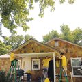 Volunteers from Living Word Lutheran Church work Saturday on painting and patching the exterior of M...