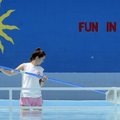 Kayla Waldrup, a lifeguard at the Lake Atalanta Pool, cleans debris out of the water Sunday before t...