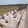 Players share a dugout with scaffolding and building material on Thursday at Har-Ber High School.