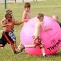 Second-graders chase down a giant windblown volleyball Tuesday during a Fun and Field day at Elm Tre...