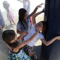 Chloe Keller, 9, from bottom, Ashley Meyl, 9, and Quinn Davis, 9, play Wednesday in a cooling founta...