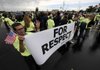 Guillermo Ruiz of Dallas holds a sign Thursday as members of the groups Making Change at Walmart and Organization United for Respect at Walmart gather around Walmart representatives outside the company’s home office.
