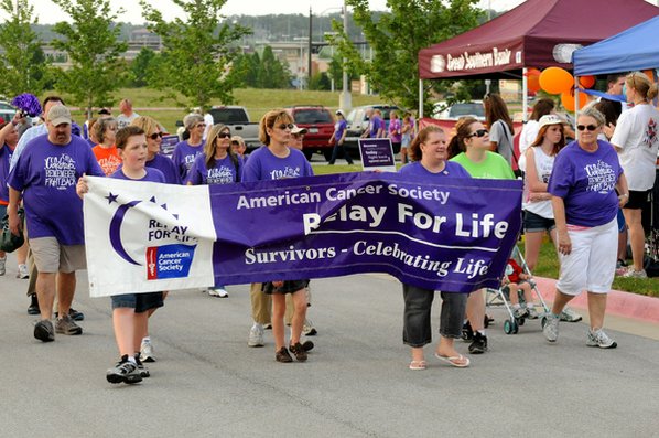 Cancer survivors wearing purple walk ...