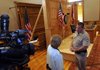  Mary Ann Gunn, left, talks on Saturday with Bobby McDonald with the Washington County Sheriff’s Office about her new television show “Last Shot With Judge Gunn” at the Historic Washington County Courthouse in Fayetteville. The producers of the show had a replica of the backdrop built so the show could place cameras where they needed without damaging the courtroom.
