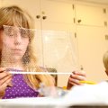 Braeden Buhlig, 7, right, watches as Katie Gustavus, 9, builds a toy soccer net Monday at Camp Bella...