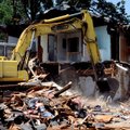 James Barker with M & M Excavating tears down a house Monday at 1807 Lowell Road in Springdale. The ...