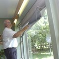 Orlo Stitt demonstrates the two-shade system that helps keep his home cool during summer and warm in...