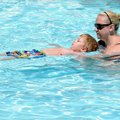 Caleb Turner, 4, learns to float with help from swimming instructor Jessica Ward at Lake Atalanta Po...