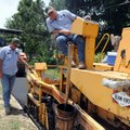 Kent Cornett, left, and Mike Gibbs, both with the city of Springdale street department, pave a walki...