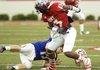  Fayetteville’s Chris Smith watches as Seth Keese of Harding Academy loses his helmet after a hard hit by Smith on Thursday during the Arkansas High School Coaches Association All-Star Football Game in Reynolds Razorback Stadium in Fayetteville. The East won 32-3.